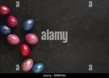 Background with painted colorful Easter eggs with golden spots, copy space Stock Photo