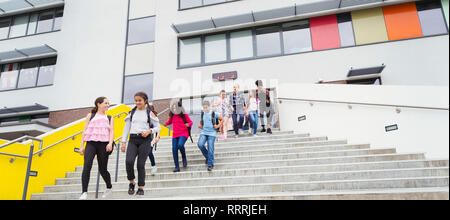 Junior high students leaving school building, descending steps Stock Photo