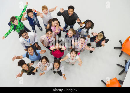 Portrait from above of enthusiastic junior high students and teachers cheering Stock Photo