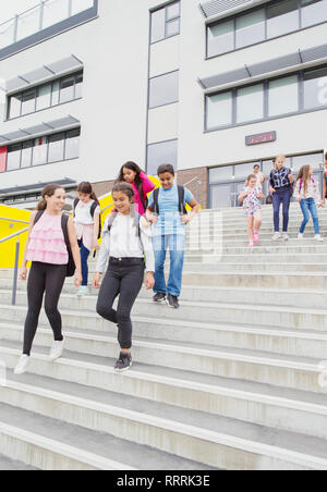 Junior high students leaving school building, descending steps Stock Photo