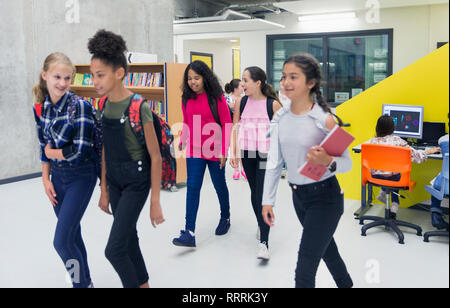 Junior high girl students walking in library Stock Photo