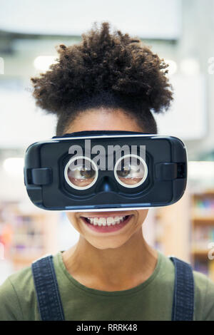 Portrait silly, cross-eyed junior high girl student wearing virtual reality simulator Stock Photo