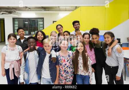 Portrait happy junior high students and teachers in library Stock Photo