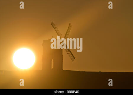 The Sun rises behind Chesterton Windmill in Warwickshire on 26 February 2019. Stock Photo
