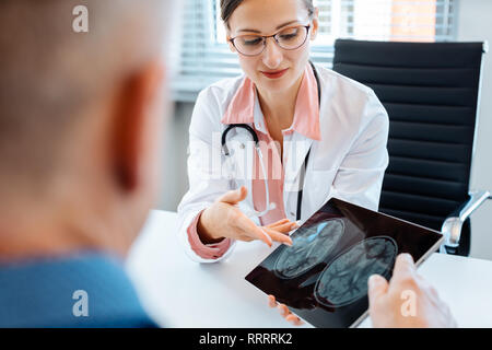 Concerned doctor showing x-ray to patient man Stock Photo