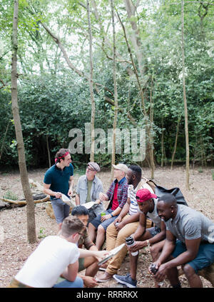 Mens group with maps and water bottles on hike in woods Stock Photo