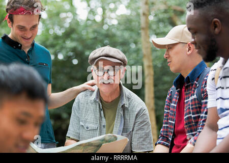 Portrait smiling man with map on hike with friends Stock Photo