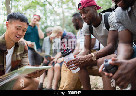 Men friends looking at hiking map in woods Stock Photo