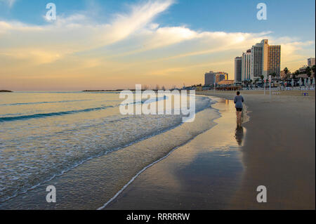 Person going for a morning jog along the Tayelet, Tel Aviv's urban beach, Tel Aviv, Israel Stock Photo