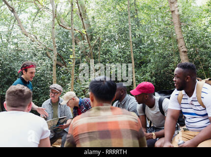 Mens group with map preparing for hike in woods Stock Photo