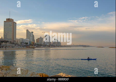 Man in a kayak at dawn, urban beach of Tel Aviv, Israel Stock Photo