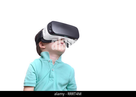 Amazed teen boy wearing virtual reality goggles watching movies or playing video games, isolated on white. Surprised teenager looking in VR glasses. E Stock Photo