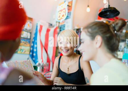 Young women friends looking at map in restaurant Stock Photo