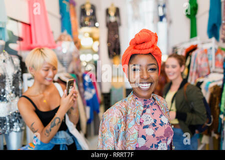Portrait enthusiastic young woman shopping with friends in clothing store Stock Photo