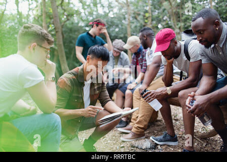 Mens group with map preparing for hike in woods Stock Photo
