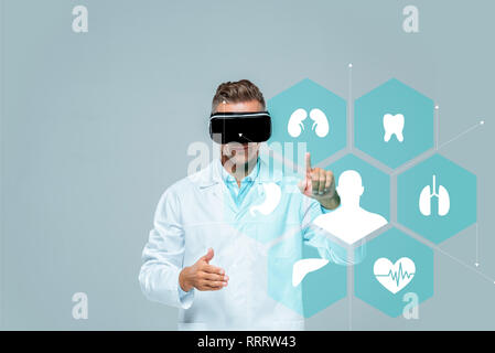 scientist in virtual reality headset touching medical interface isolated on grey, artificial intelligence concept Stock Photo