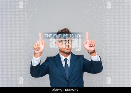 handsome businessman in glasses touching something isolated on grey, artificial intelligence concept Stock Photo