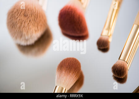 Different make-up brushes on a mirror Stock Photo