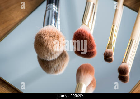 Different make-up brushes on a mirror Stock Photo