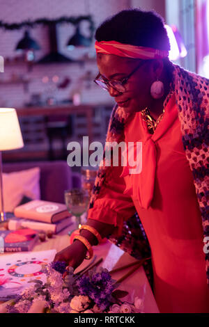 African american plump fortune-teller with a golden watch looking pleased Stock Photo