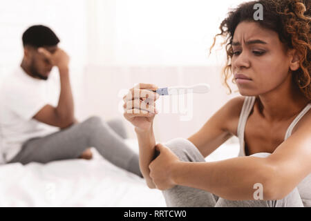 Thoughtful girl undergoing pregnancy test near boyfriend Stock Photo