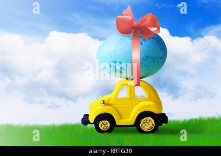 Retro toy car with Easter egg on the roof. on spring background Easter concept. Happy Easter. Stock Photo