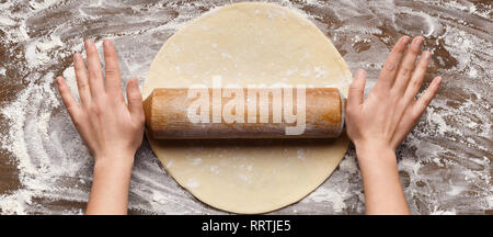 Chef rolling dough for pizza on table Stock Photo