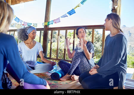 Women talking in hut during yoga retreat Stock Photo