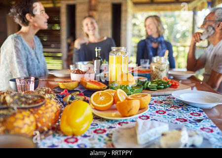 Friends enjoying healthy breakfast at table during yoga retreat Stock Photo