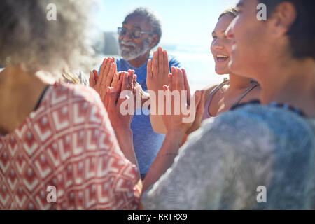 Friends with hands clasped in circle enjoying yoga retreat Stock Photo