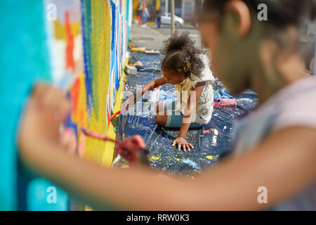 Girls painting mural on wall Stock Photo