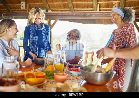 Friends enjoying healthy meal in hut during yoga retreat Stock Photo