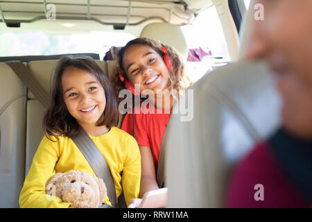 Happy sisters riding in back seat of car Stock Photo