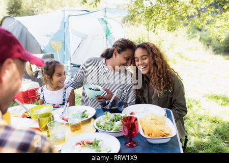 Affectionate, happy family enjoying lunch at campsite table Stock Photo