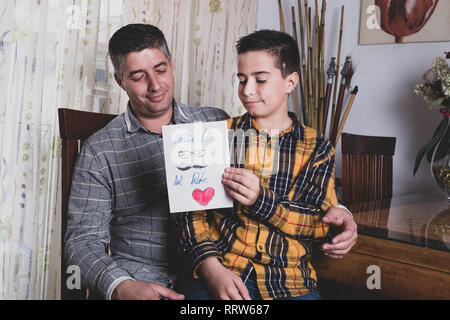 boy giving greeting card to father on father's day Stock Photo