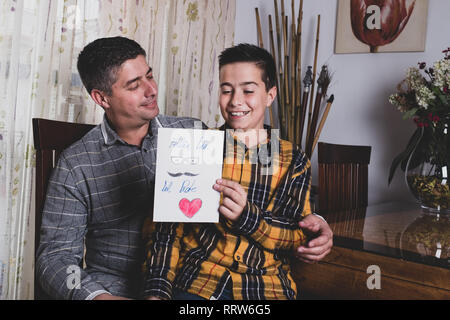 boy giving greeting card to father on father's day Stock Photo