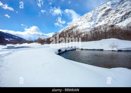 Sunny winter mountain landscape with a bubbling mountain river Stock Photo