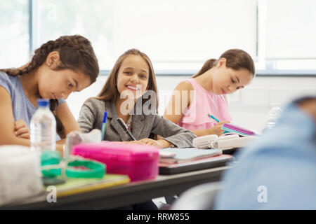 Portrait smiling, confident junior high school girl student studying in classroom Stock Photo