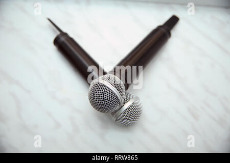 close up two microphone for duo sing a song concept . Two silver microphones isolated over white background Stock Photo