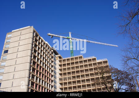 Skeleton of abandoned office building with large crane Stock Photo