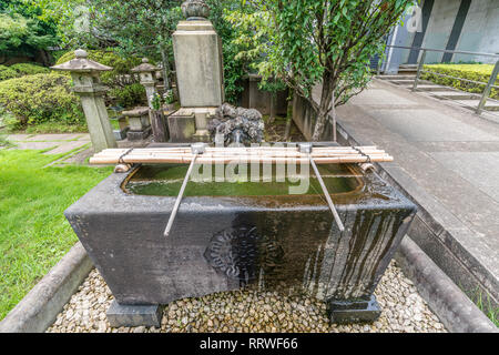 Yanaka, Tokyo, Japan - August 18, 2017 : Stone Chozuya or Temizuya (Water ablution pavilion) of Tennoji Temple of Tendai sect of Buddhism. Located in  Stock Photo