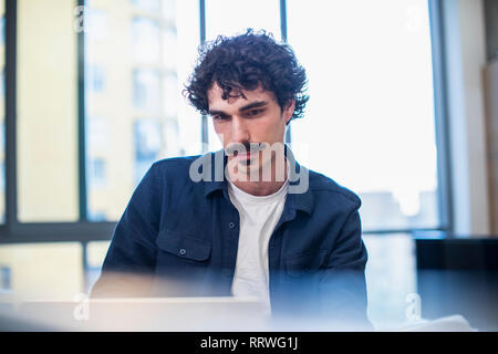 Focused man using laptop at home Stock Photo