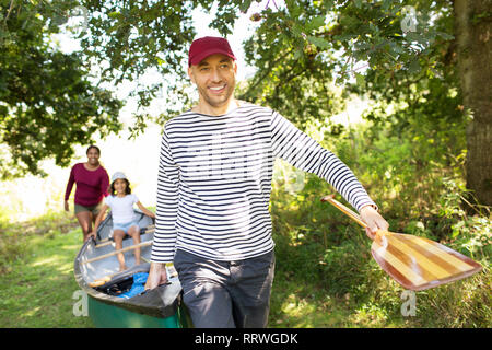 Family carrying canoe in woods Stock Photo