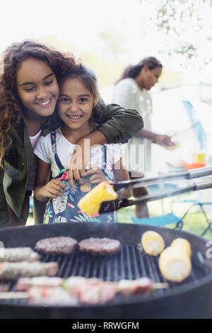 Portrait affectionate sisters enjoying barbecue Stock Photo