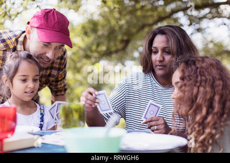 Family playing cards at campsite Stock Photo