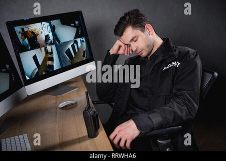 handsome guard in uniform sleeping at workplace Stock Photo