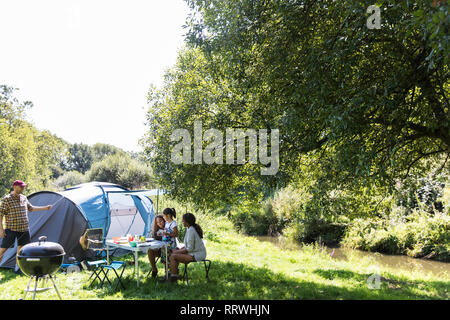Family at sunny campsite Stock Photo