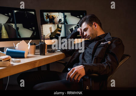 guard in black uniform sleeping at workplace Stock Photo