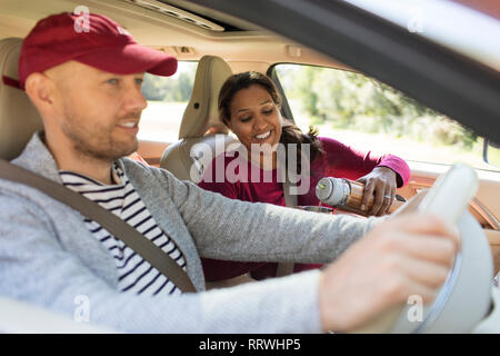 Couple drinking coffee in car on road trip Stock Photo