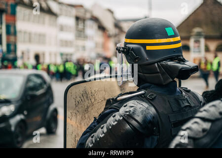 Proestor Shield A protester wearing a yellow safety vest and a respirator holds a ...